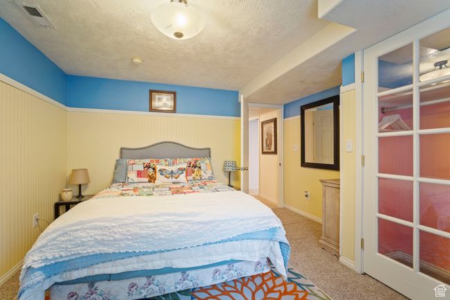 Bedroom with carpet flooring, a textured ceiling, visible vents, and baseboards | Image 24