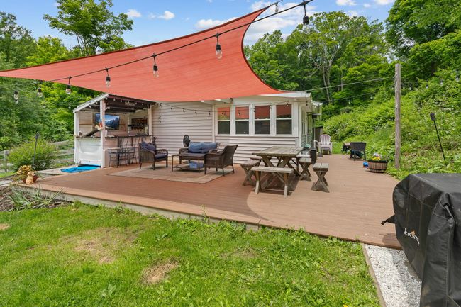 Wooden terrace with an outdoor living space, grilling area, and a lawn | Image 10