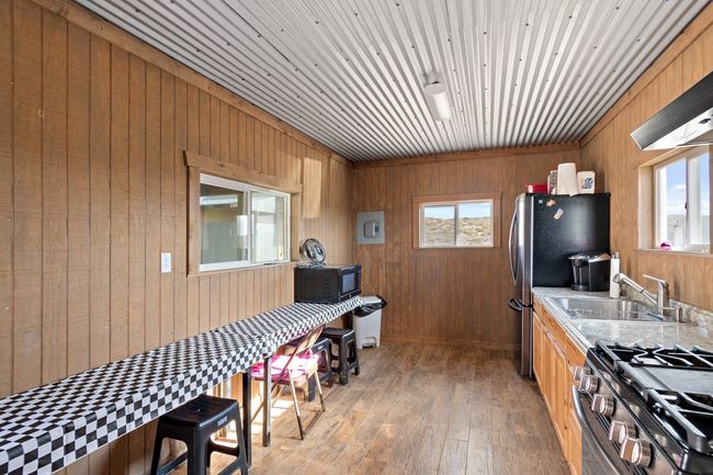 Kitchen featuring light hardwood / wood-style flooring, a wealth of natural light, wooden walls, and sink | Image 20