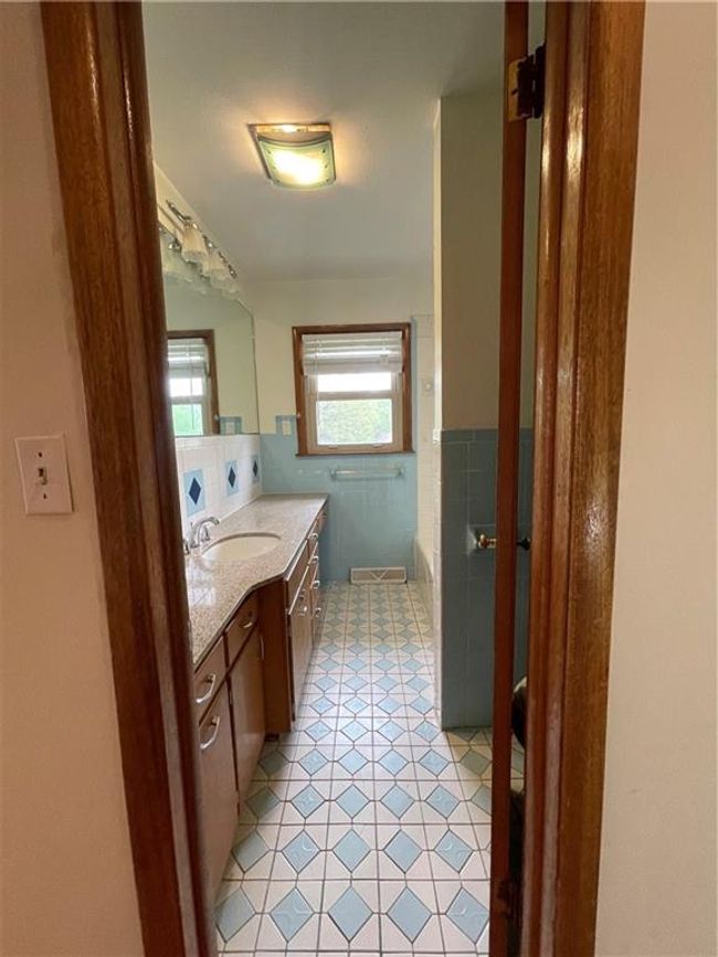 Full bath featuring tile patterned floors, a bathtub, tile walls, and vanity | Image 20