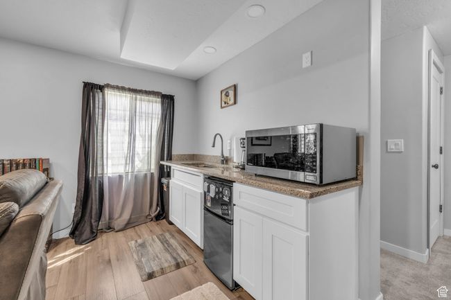 Kitchen with a sink, stainless steel microwave, recessed lighting, white cabinetry, and dishwasher | Image 24