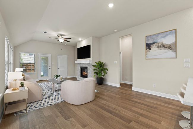 Living room featuring ceiling fan, wood finished floors, a glass covered fireplace, recessed lighting, and lofted ceiling | Image 12