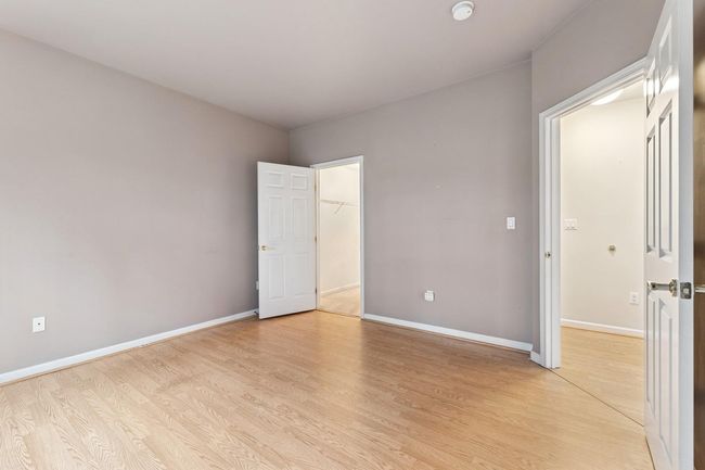 Main floor primary bedroom has large walk-in closet, laminate wood flooring | Image 7