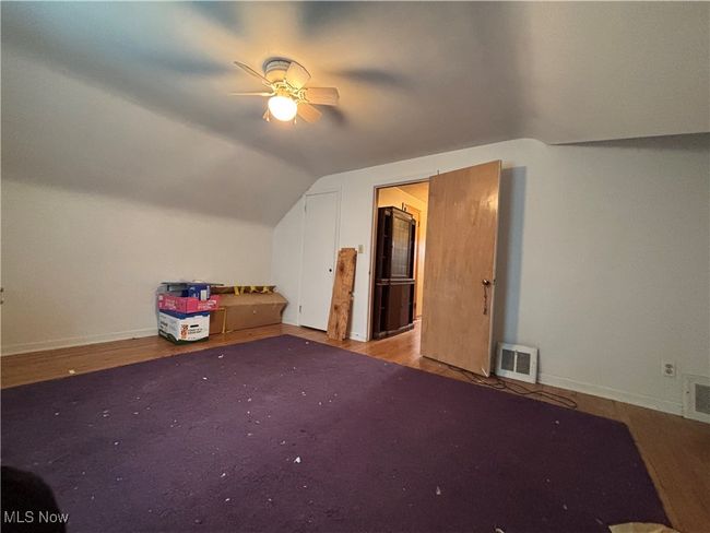 Additional living space featuring ceiling fan, baseboards, visible vents, and vaulted ceiling | Image 10