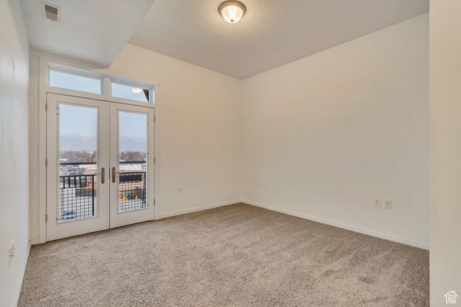Carpeted spare room featuring baseboards, visible vents, french doors, and a textured ceiling | Image 14