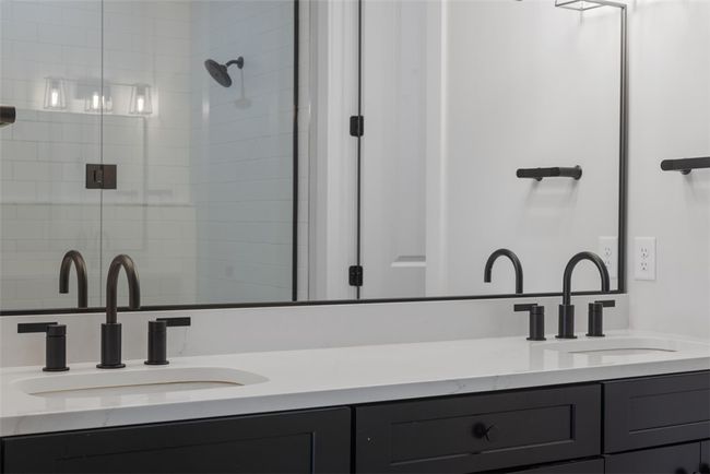 Primary bathroom with tiled floor and shower, double bowl vanity with quartz counter top, decorative mirrors, additional lighting | Image 21