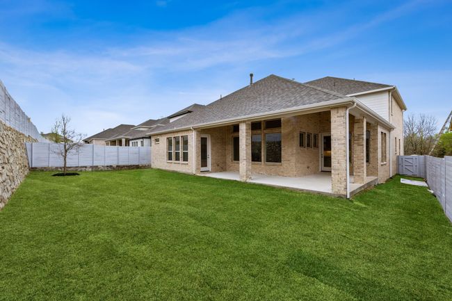 Rear view of house with a shingled roof, brick siding, a fenced backyard, and a patio | Image 36
