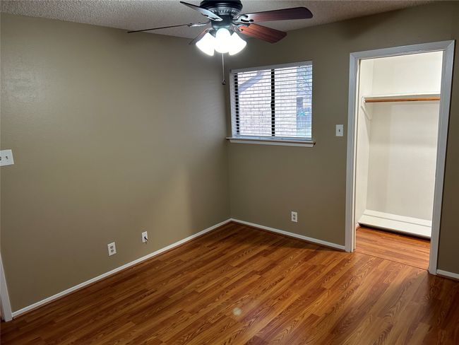 Unfurnished bedroom featuring ceiling fan, wood-type flooring, a closet, and a textured ceiling | Image 17