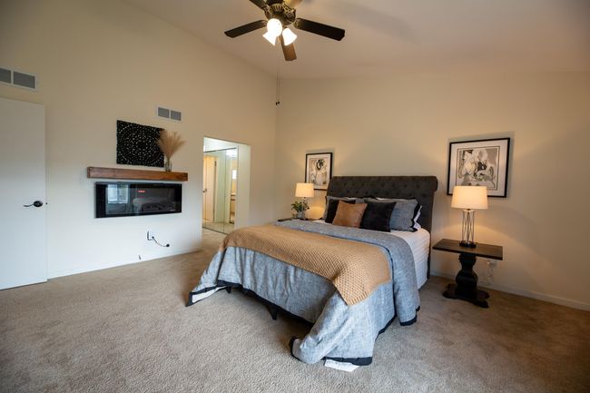 Primary Suite with high ceilings, electric fireplace, large closets and neutral paint. | Image 13