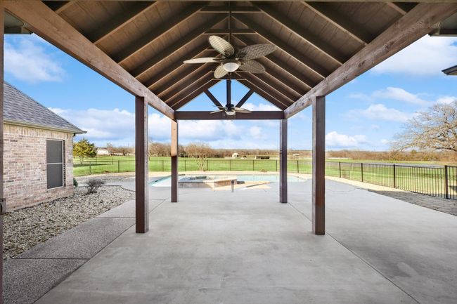 Fenced backyard with ceiling fan, an outdoor hot tub, and a patio | Image 23