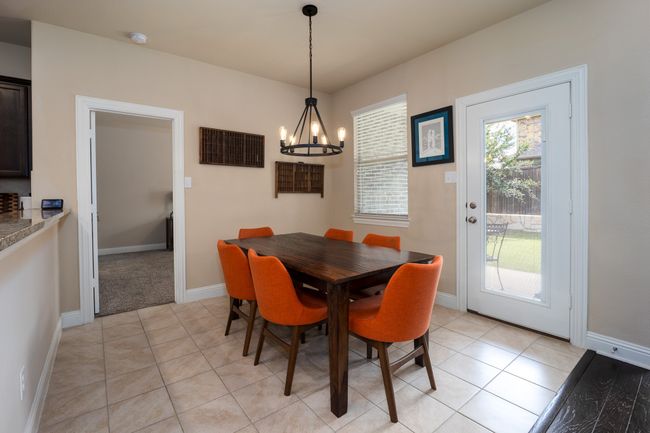 Dining area with a chandelier and light tile patterned flooring | Image 4