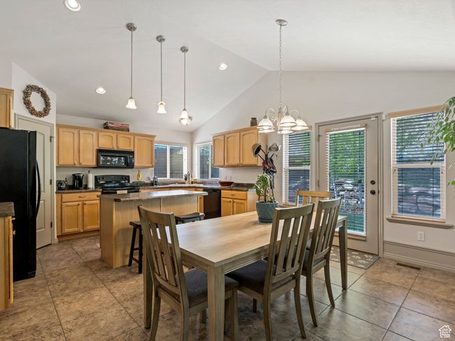Tiled dining room with a chandelier, a sink, recessed lighting, and high vaulted ceiling | Image 15