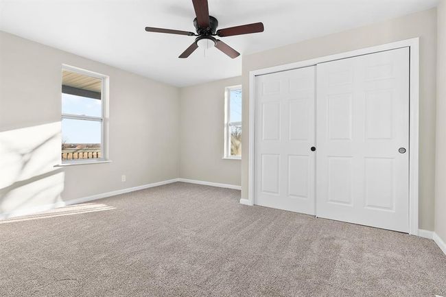 Unfurnished bedroom with carpet, baseboards, a closet, and a ceiling fan | Image 18