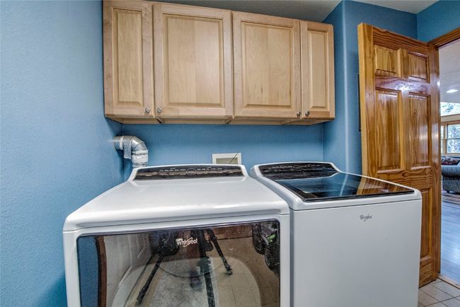 Washroom featuring washer and clothes dryer and cabinet space | Image 17
