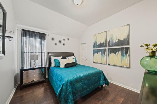 Light and airy with vaulted ceilings and soft natural light, this bedroom offers a peaceful retreat and features a spacious walk-in closet. | Image 42