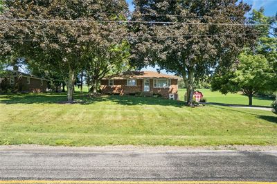 Single story home with a storage unit and a front yard | Image 2