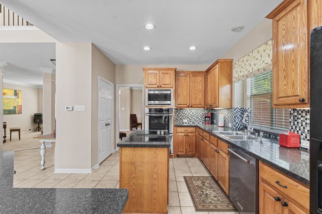 Kitchen with appliances with stainless steel finishes, a sink, light tile patterned floors, a center island, and recessed lighting | Image 10