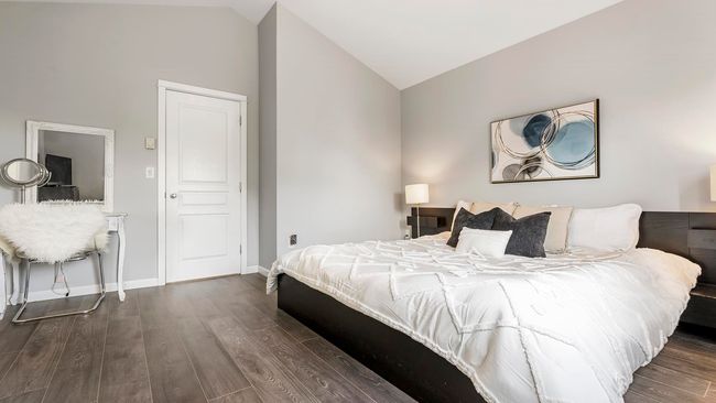 Bedroom featuring lofted ceiling, baseboards, and dark wood-style flooring | Image 18