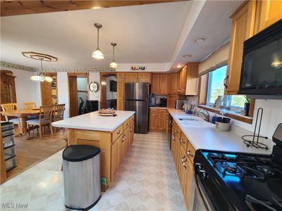 Kitchen featuring a center island, pendant lighting, and an inviting chandelier | Image 2