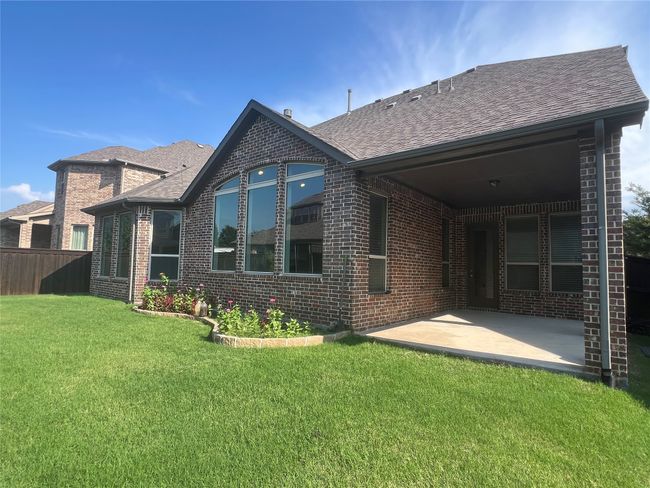 Rear view of house featuring brick siding, a patio, and a shingled roof | Image 38