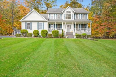 Colonial-style house featuring covered Trex porch and a front yard | Image 2