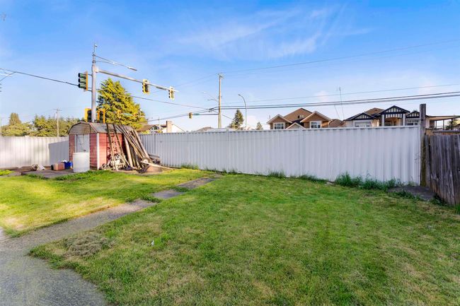 Fenced backyard with a storage unit | Image 24