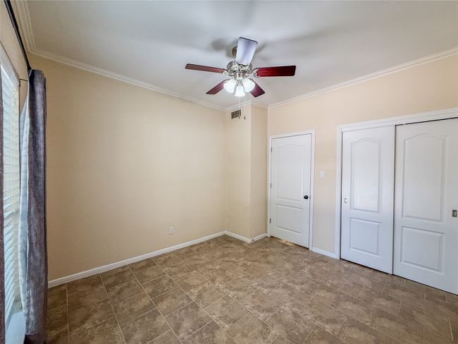 Unfurnished bedroom with ornamental molding, a closet, and a ceiling fan | Image 19