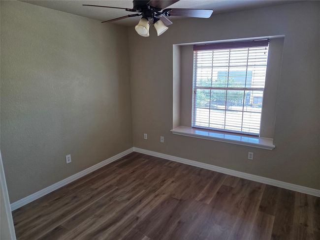 Spare room featuring dark wood-type flooring and a ceiling fan | Image 19
