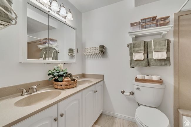 Bathroom with double vanity, toilet, and a shower | Image 10