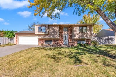 Bi-level home with a front lawn and a garage | Image 2