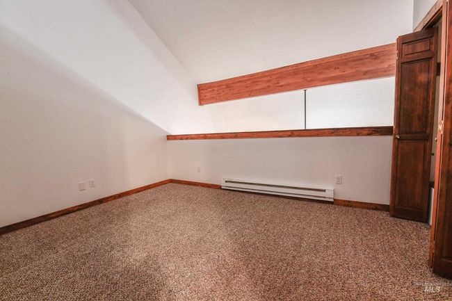 Empty room featuring baseboard heating, lofted ceiling, and carpet floors | Image 15