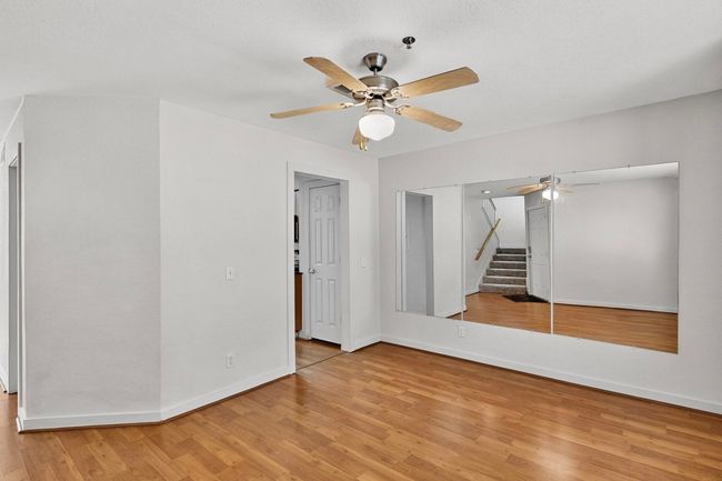 Unfurnished room with light wood finished floors, stairway, and ceiling fan | Image 20