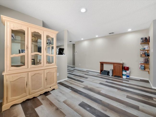 Bar featuring light brown cabinets, a textured ceiling, and hardwood / wood-style flooring | Image 8