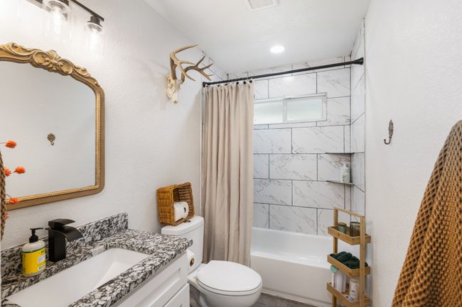 Bathroom featuring vanity and shower / tub combo with curtain | Image 16