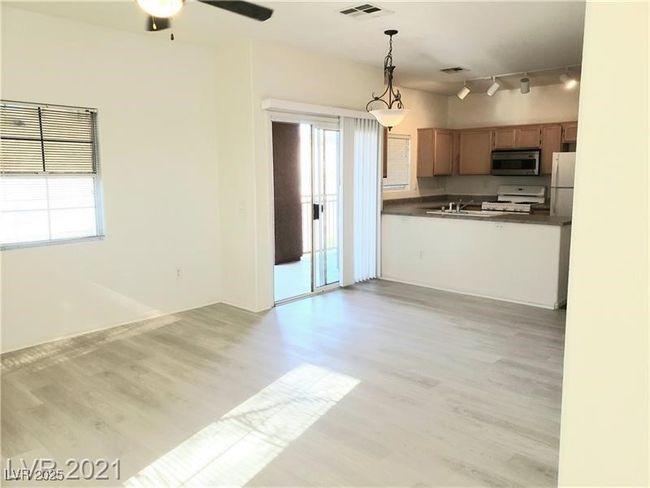 Kitchen featuring stainless steel microwave, dark countertops, freestanding refrigerator, stove, and light wood finished floors | Image 5
