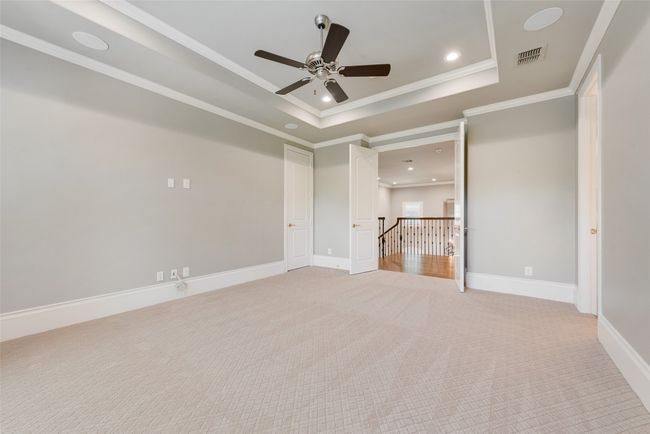 Unfurnished bedroom with a raised ceiling, visible vents, recessed lighting, light colored carpet, and ornamental molding | Image 30