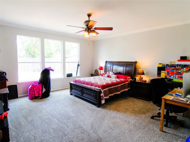 Carpeted bedroom featuring ornamental molding, ceiling fan, and baseboards | Image 8