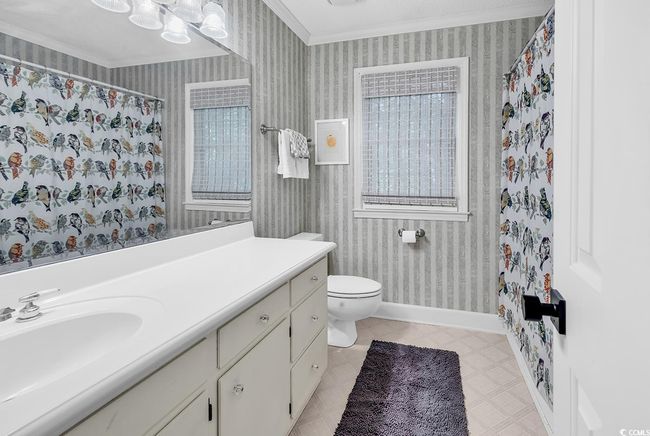 Full bathroom with crown molding, vanity, wallpapered walls, healthy amount of natural light, and a shower with curtain | Image 24