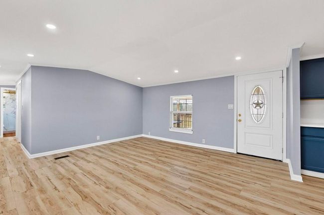 Unfurnished living room featuring light wood-style floors, baseboards, crown molding. | Image 12