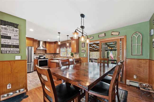Dining room with wainscoting, wood walls, and light wood finished floors | Image 14