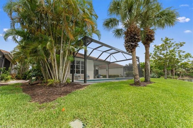 View of grassy yard with an outdoor pool and glass enclosure | Image 21