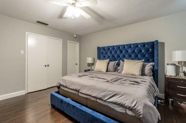 Bedroom featuring dark wood-style flooring, a ceiling fan, and baseboards | Image 13