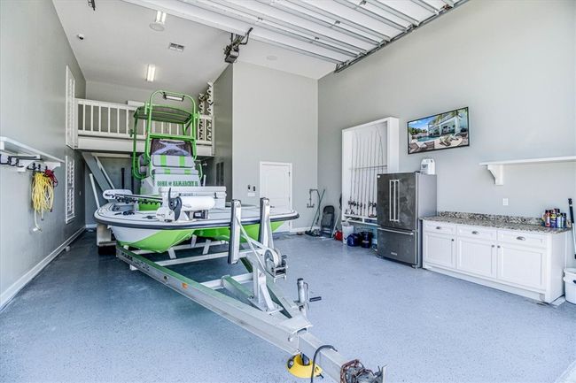 Tall boat height garage with added storage loft, custom shelving, drains and tackel/dog wash off area | Image 30