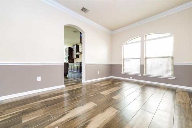 Sublime, light desert tones grace this formal dining room, with its huge double arched windows and arched entry into the kitchen, left. | Image 4