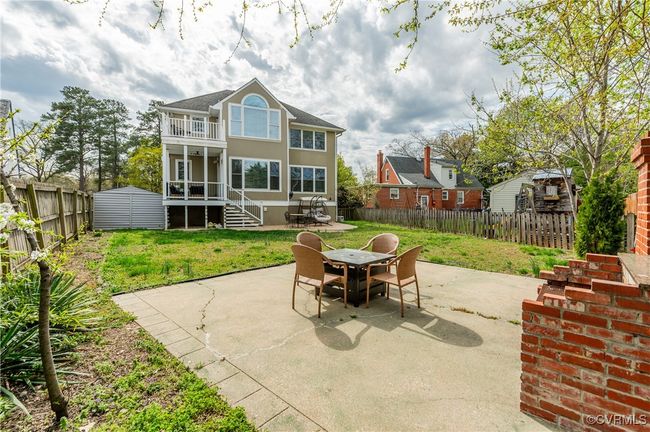 View of patio with an outbuilding, a shed, a fenced backyard, a balcony, and outdoor dining space | Image 47