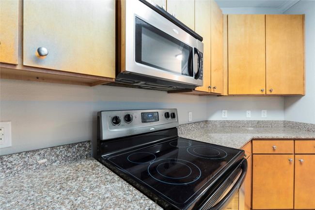 Kitchen featuring stainless steel appliances and light countertops | Image 12