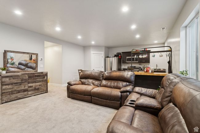 Living room with light colored carpet, bar with sink, and recessed lighting | Image 31
