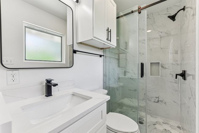 Bathroom featuring vanity and a marble finish shower | Image 23