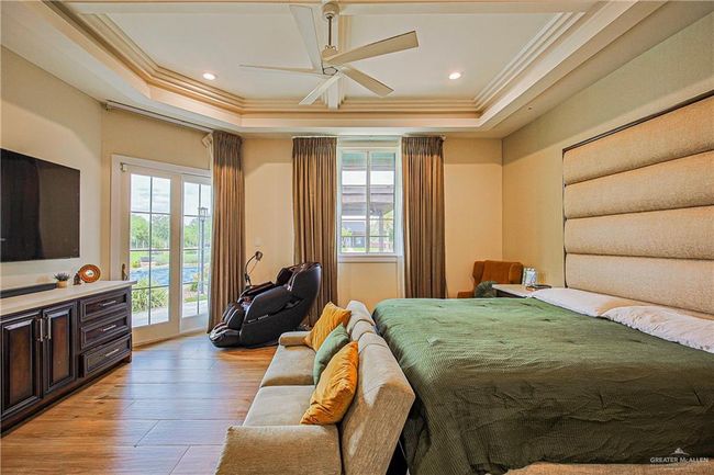 Bedroom with ornamental molding, access to outside, porcelain floors, a raised ceiling, and recessed lighting | Image 9