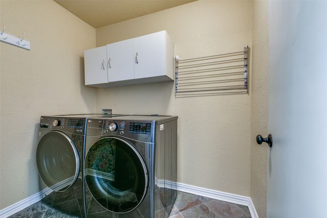 Laundry room featuring cabinet space and separate washer and dryer. | Image 20